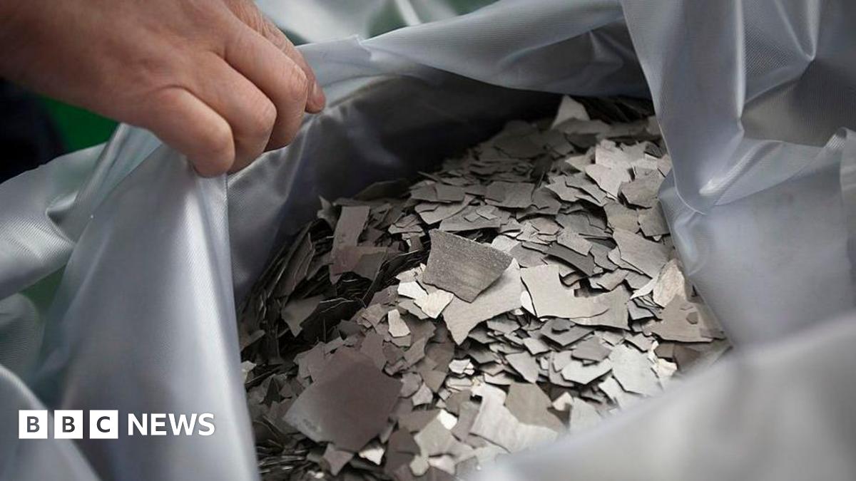 A person's hand holds open a bad of the rare earth element neodymium, which is used for producing permanent magnets.