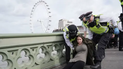 PA Media Police remove a protester after a banner was unfurled on Westminster Bridge 