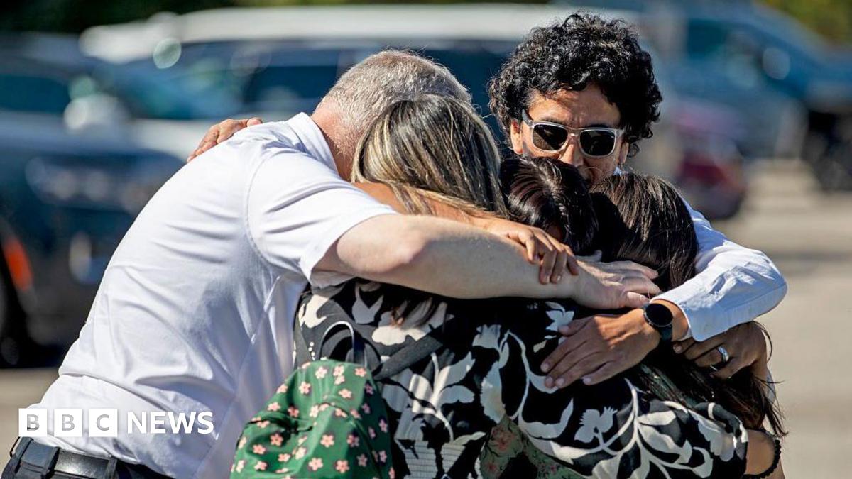 A family of five is seen embracing as they emotionally reunite at the Trillium Theater, located across the street from the site of a shooting and fire at the Church of Jesus Christ of Latter-day Saints on September 28, 2025 in Grand Blanc, Michigan.