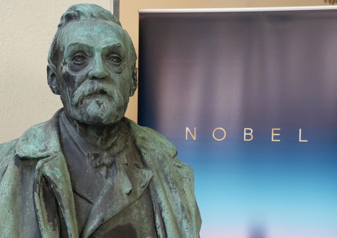 A sculpted bust of a bearded man is shown inside a room.
