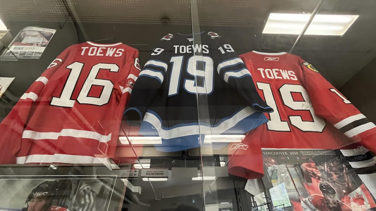 A glass display case contains photos and three hockey jerseys with the name "Toews."