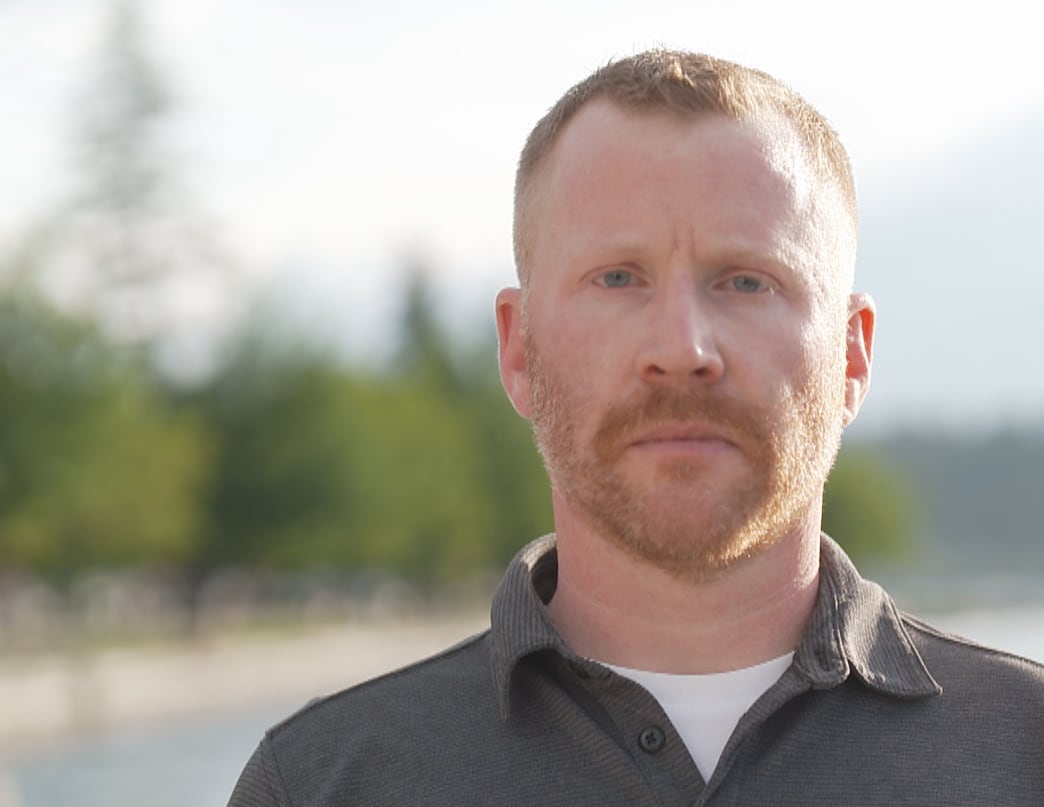 A man with short-cropped red hair and a beard looks straight on.
