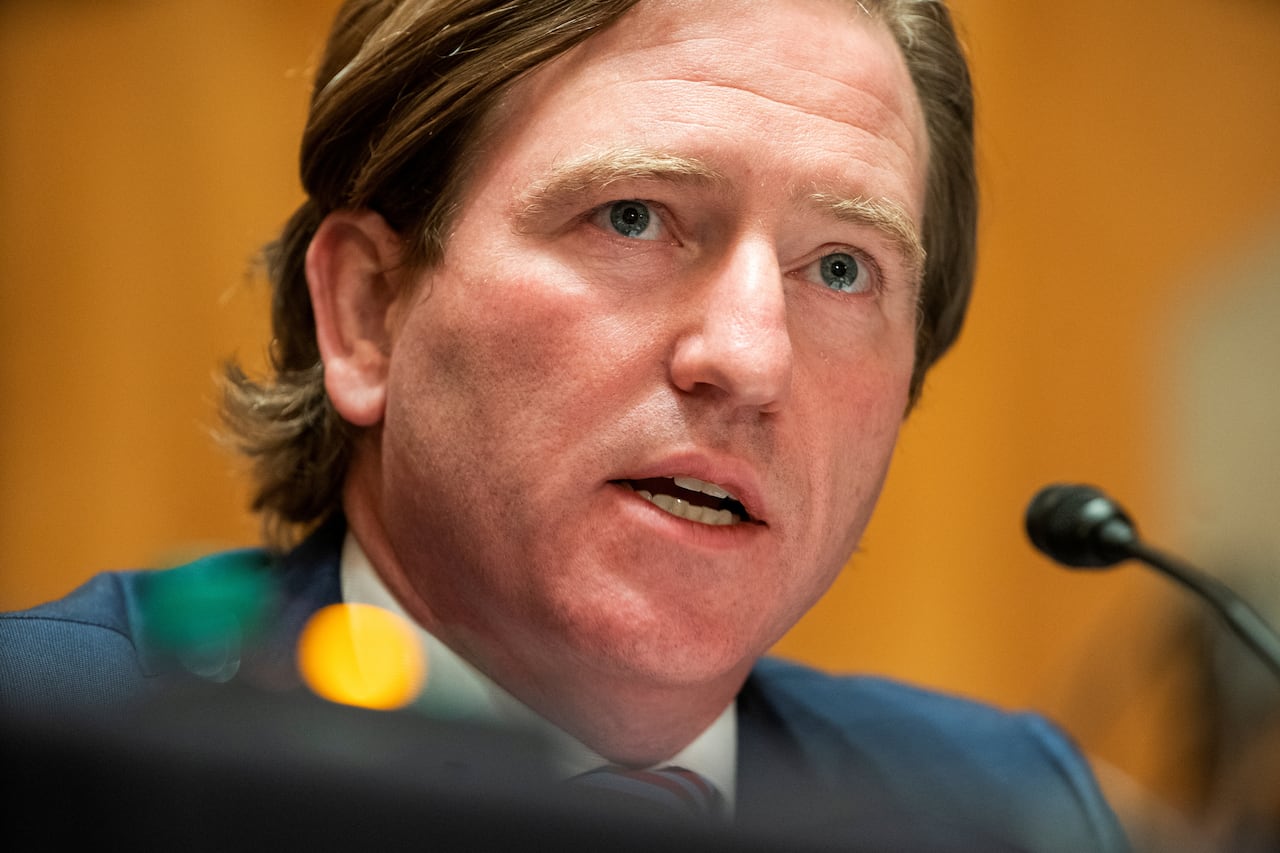 A man's cleanshaven face is shown in extreme closeup as he speaks.