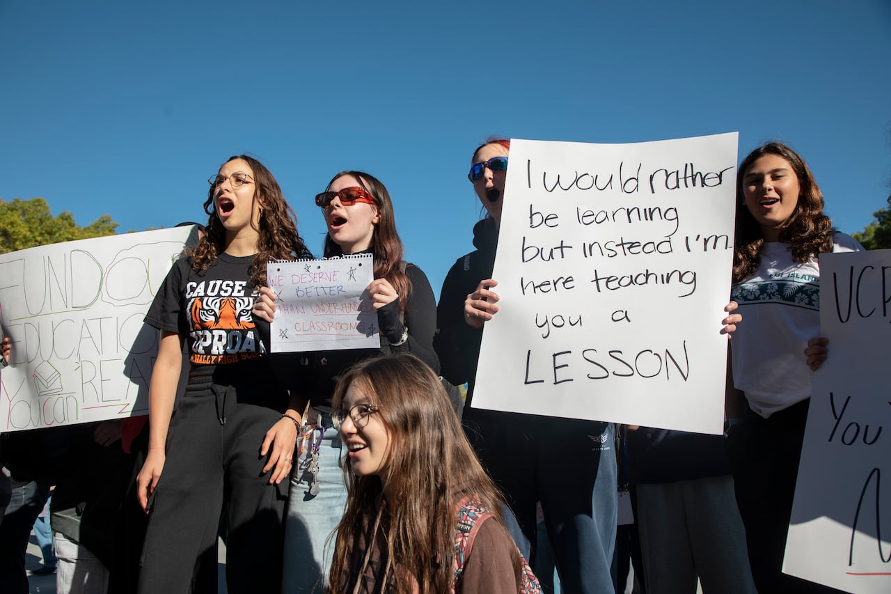 People standing with signs protesting for teachers