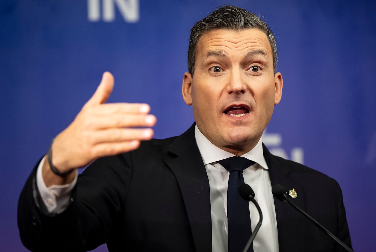 A man wearing a black suit wearing a blue tie