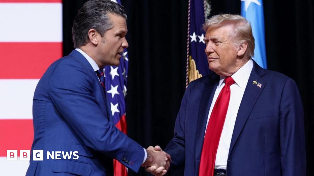 Pete Hegseth shakes Donald Trump's had while standing in front of a US flag