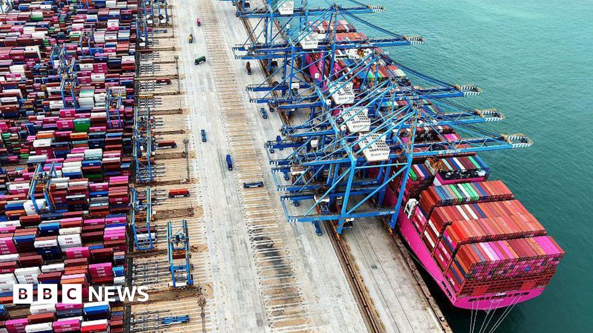 Overhead view of a container ship in a container port with many containers on the ship and also on the port side waiting to be loaded