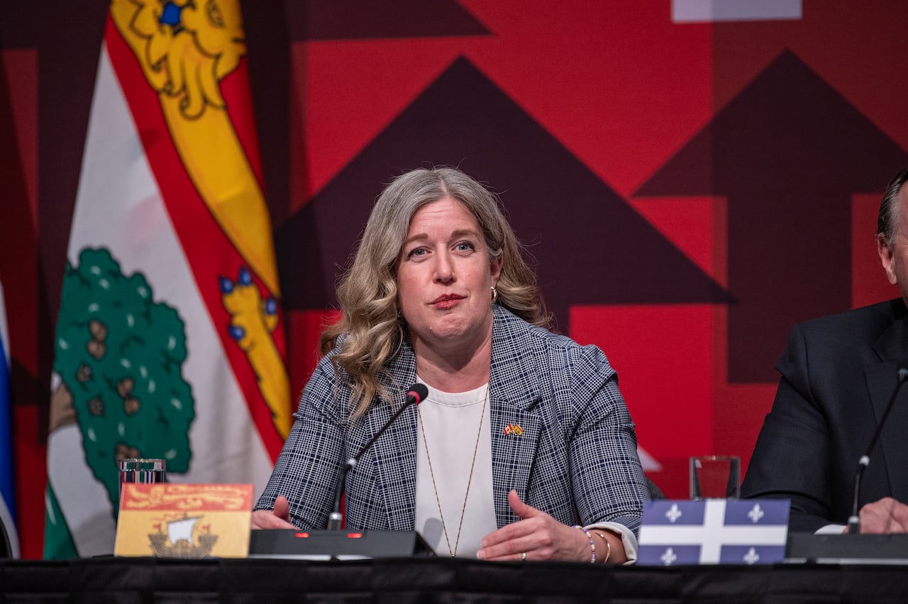 A woman with blonde hair wearing a grey jacket