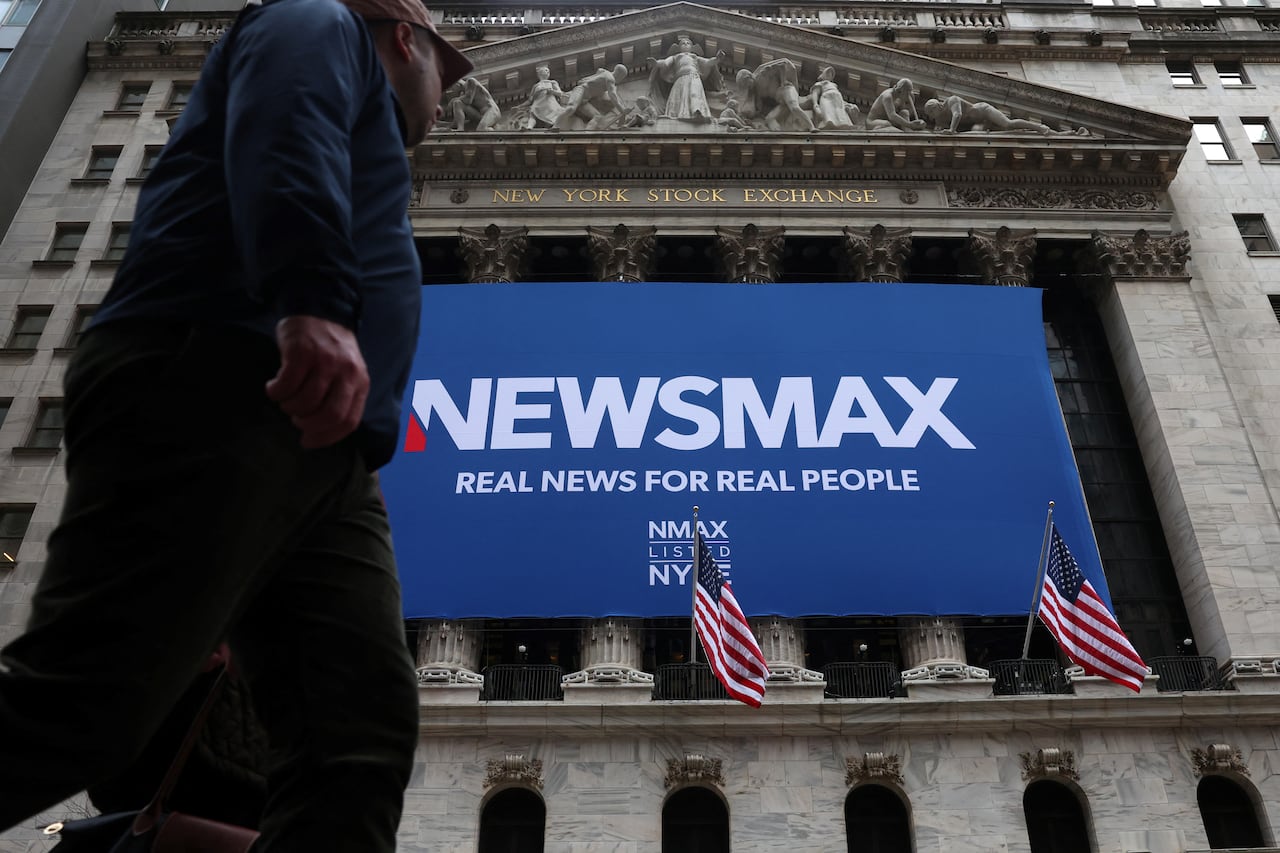 Exterior of the New york Stock exchange, flying banner that reads Newsmax