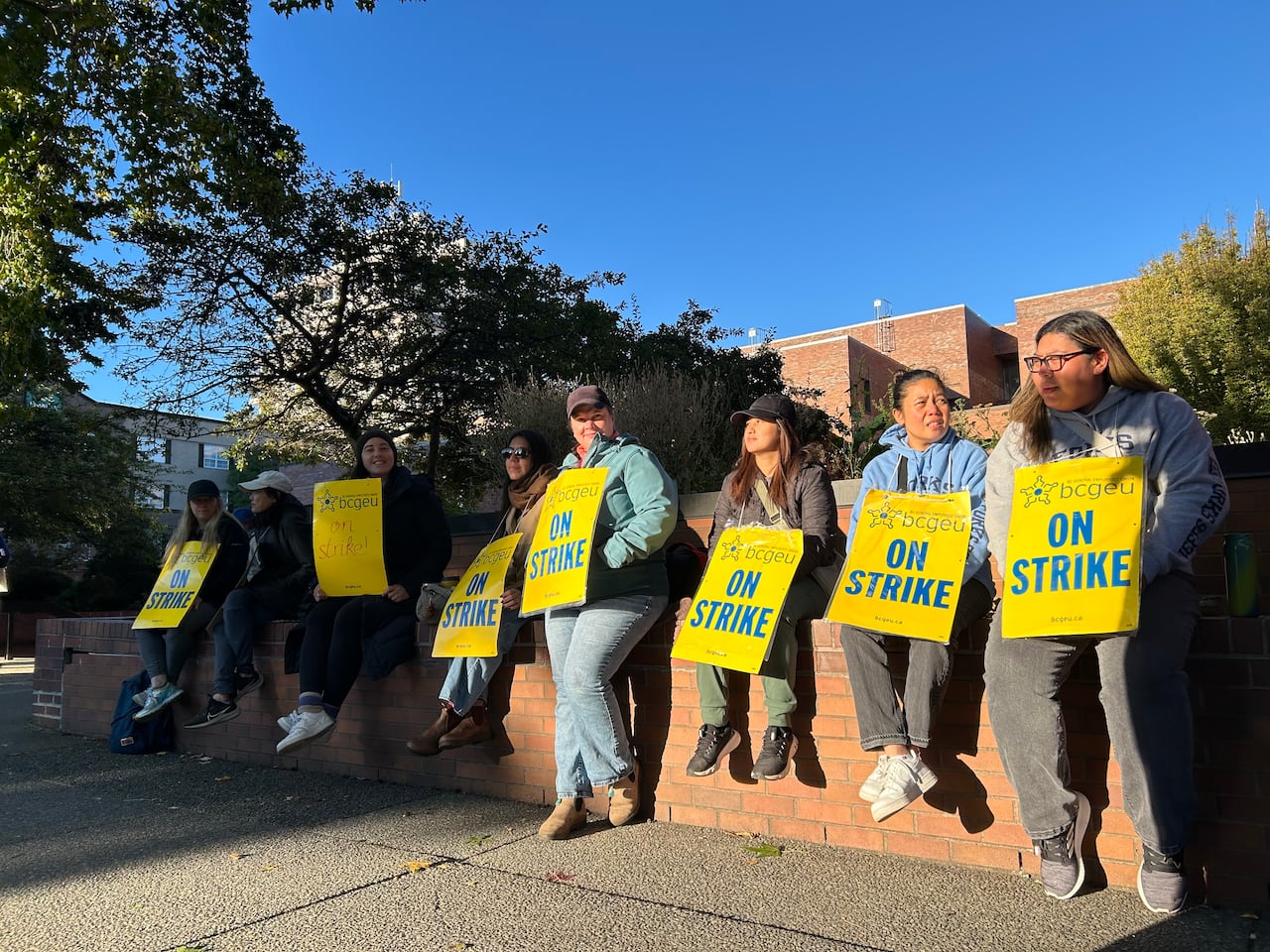 Workers sitting with picket signs
