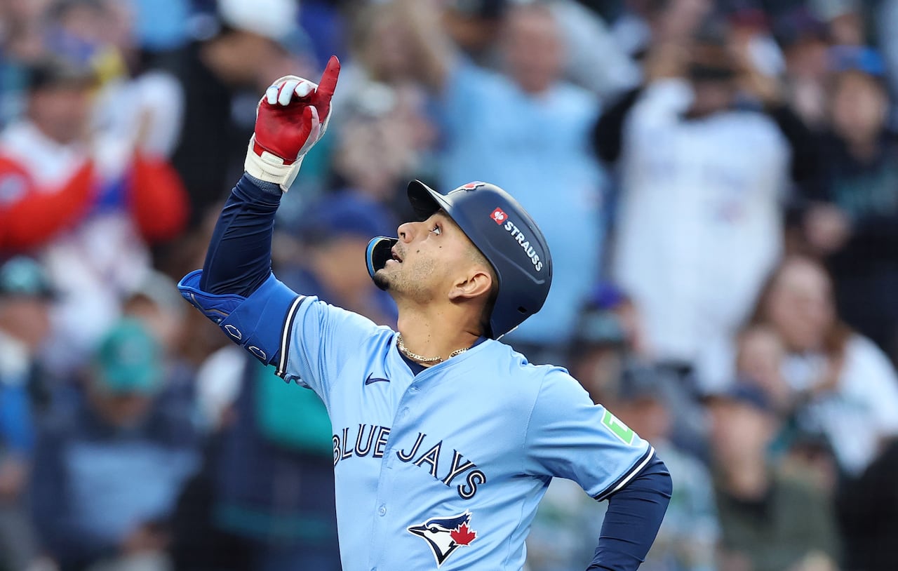 A baseball player points toward the sky