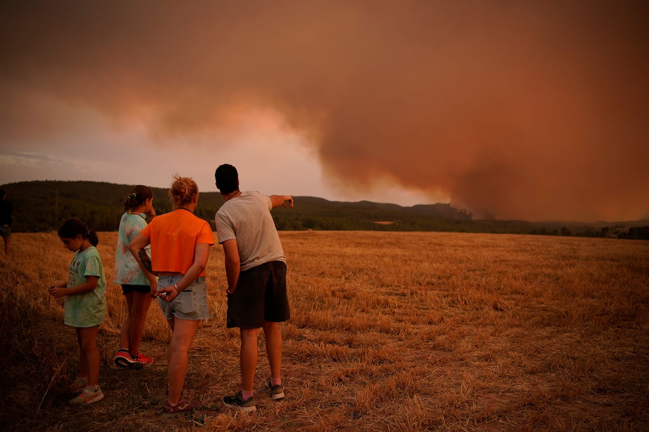 Residents look at wildfire near Tarragona, in the northeastern region of Catalonia, Spain, Sunday, July 25, 2021