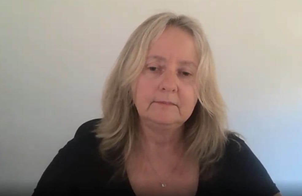 A woman in a black shirt speak on a Zoom call