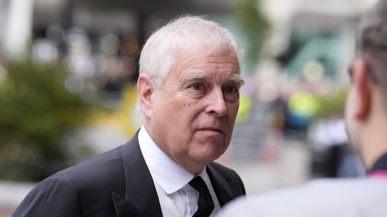A grey-haired man in a black suit walks into a cathedral.