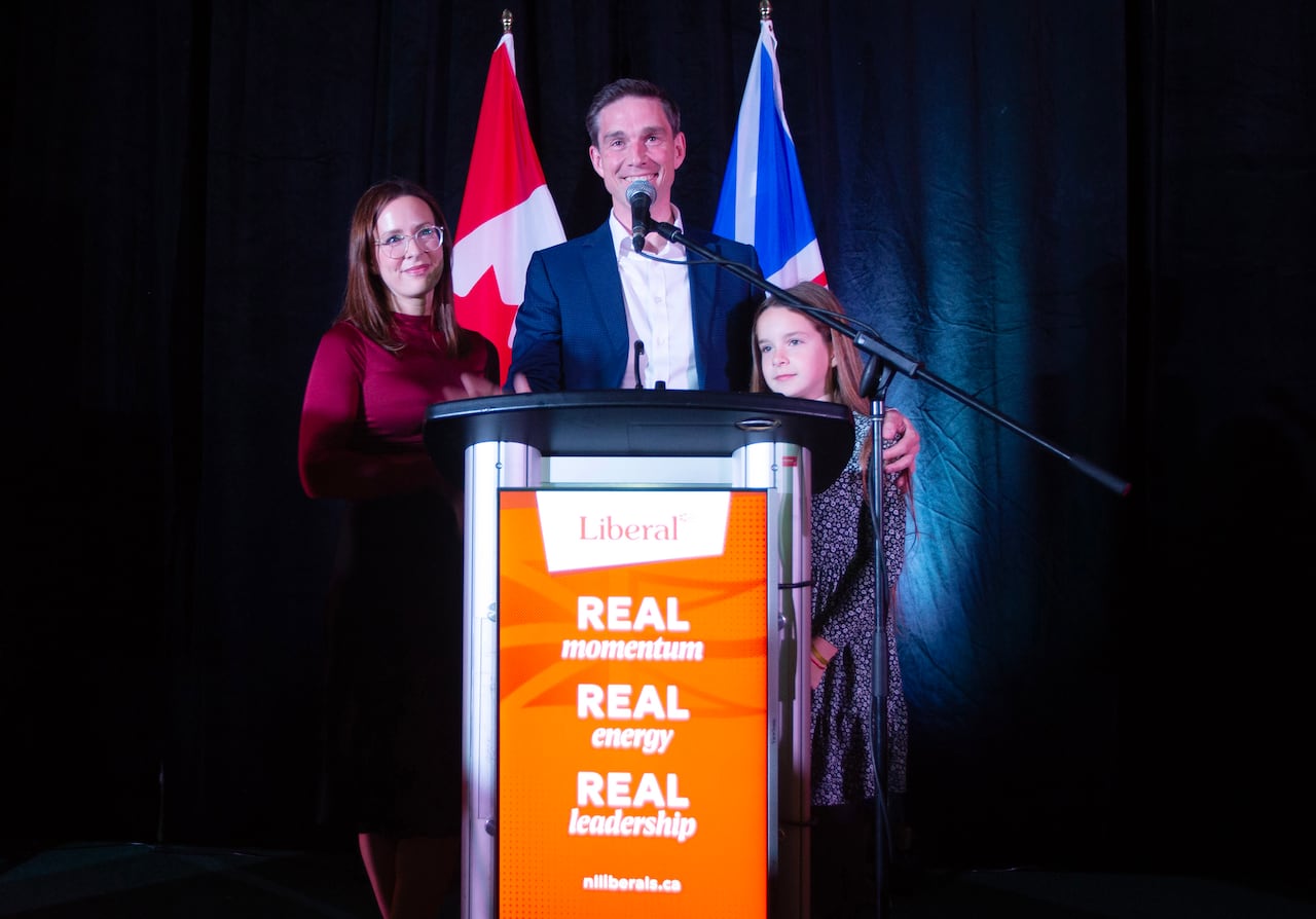 A woman, man, and child stand behind a podium 