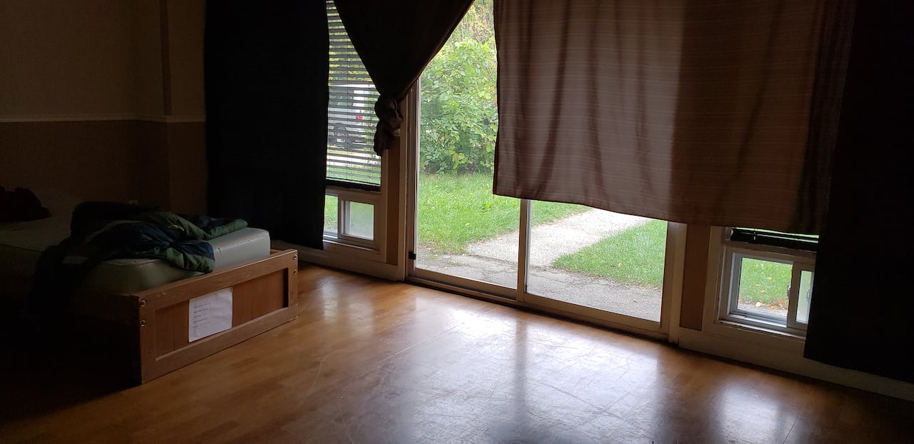 A room with a sliding glass door and tall windows. 