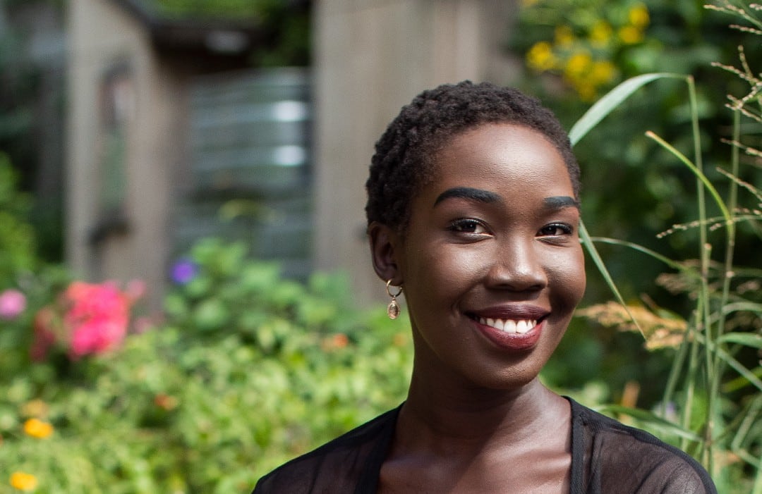 Photo of a woman sitting cross-legged on a rock.