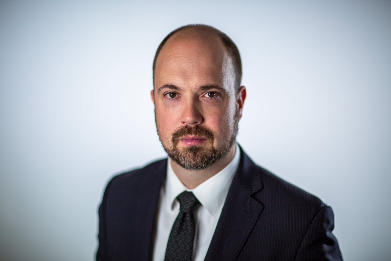 Headshot of a man wearing a suit.