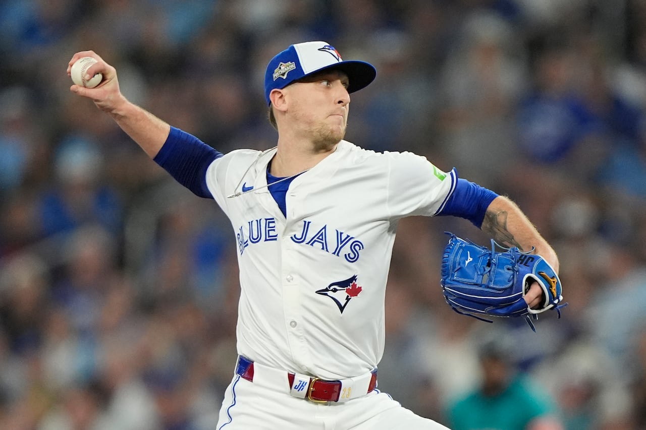 A baseball pitcher in the middle of delivering a pitch to the plate