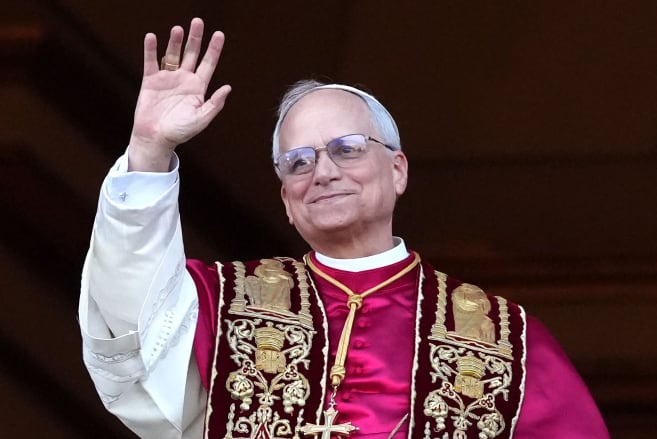 A man in papal robes waving