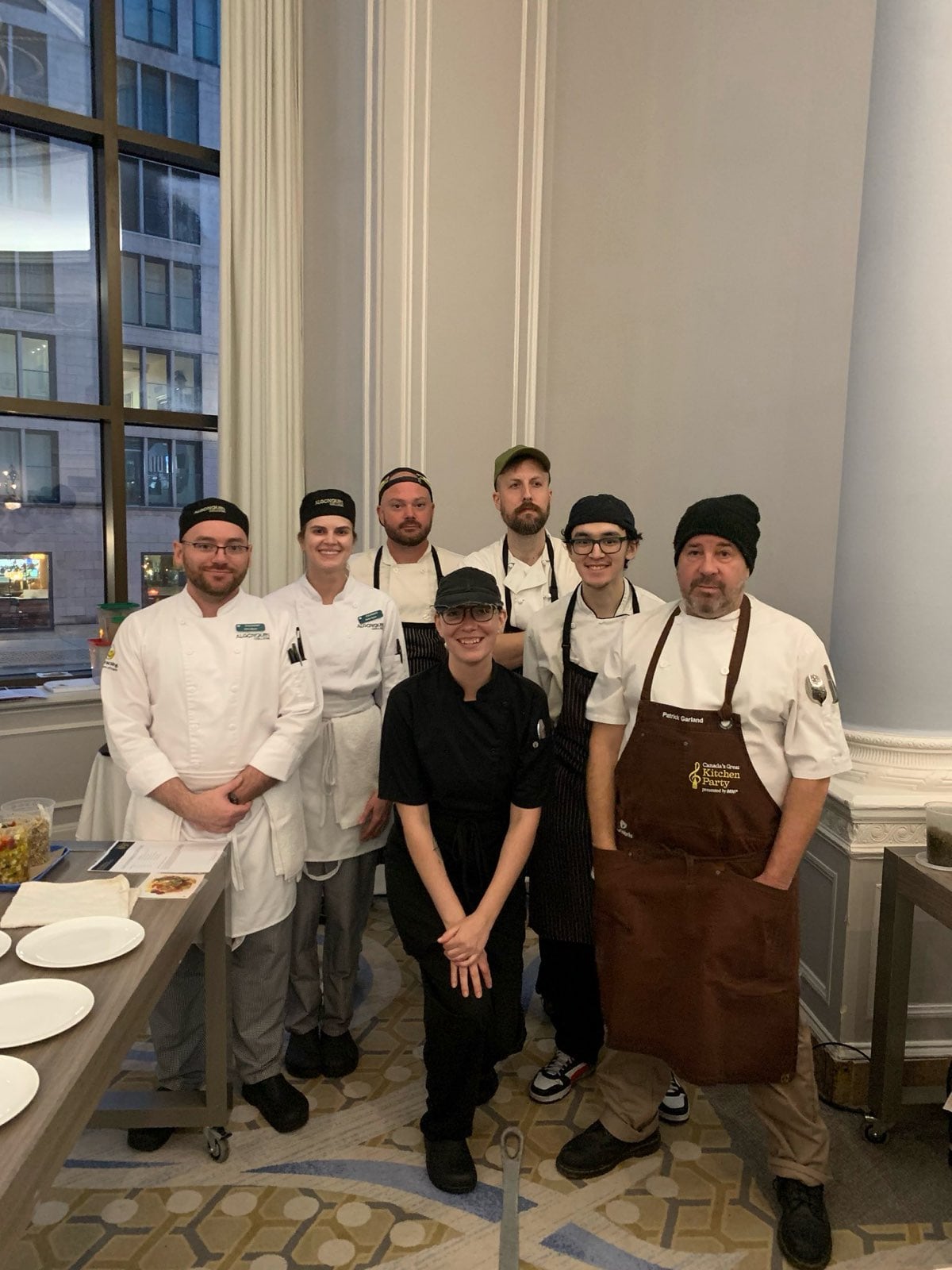 A group photo of seven chefs in a restaurant kitchen 