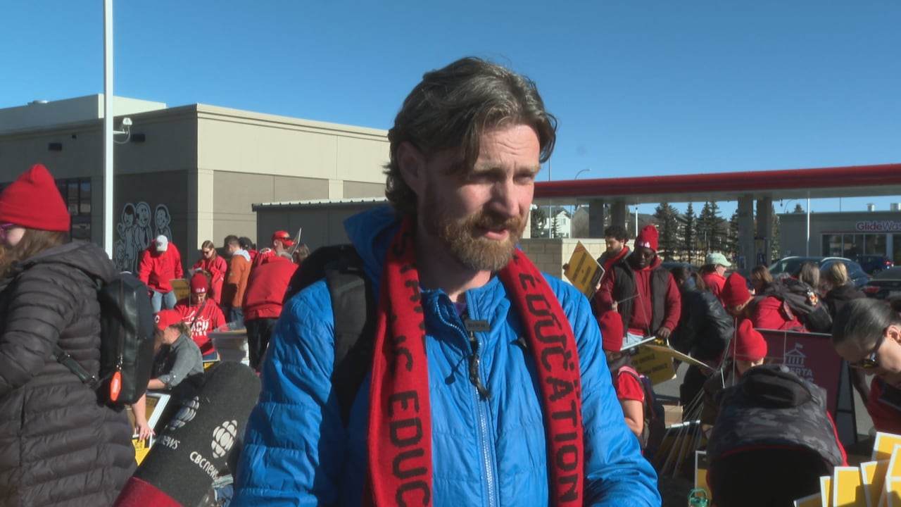 A man in a blue jacket and red scarf.