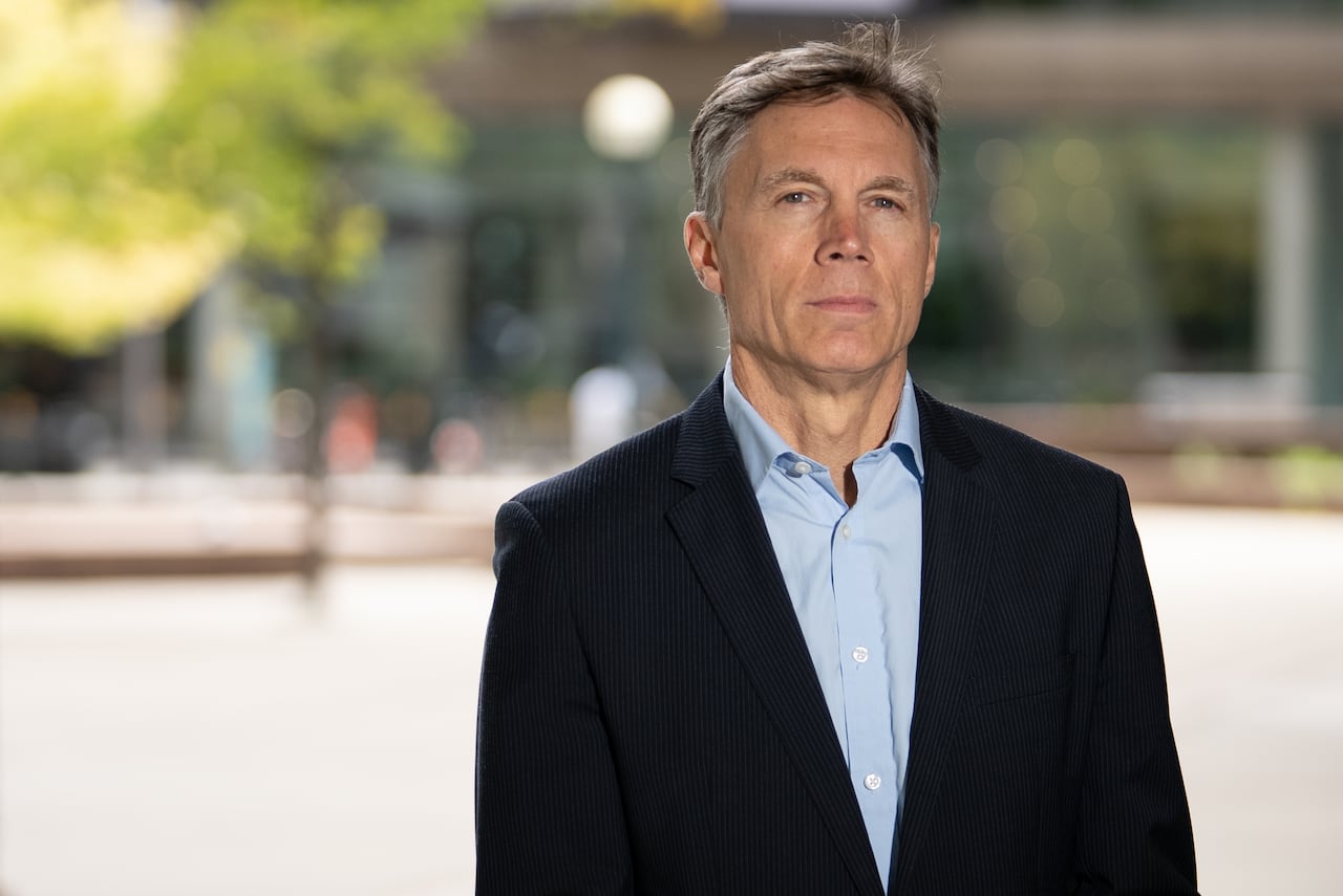 Man in suit looking at camera, not smiling