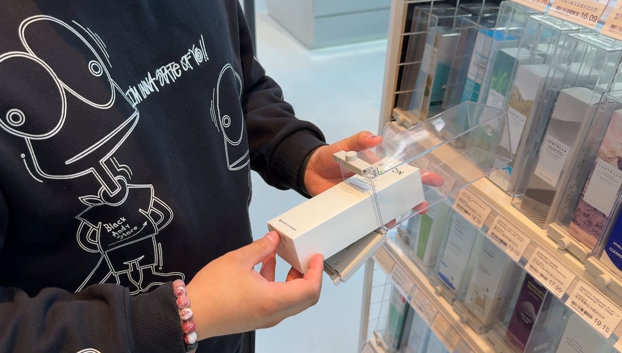 A photo of a man putting a product into a clear lockbox