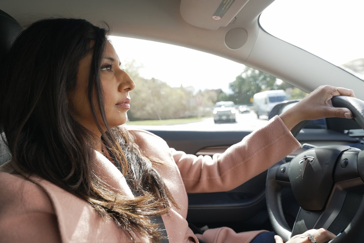 Photo of a woman driving a Tesla