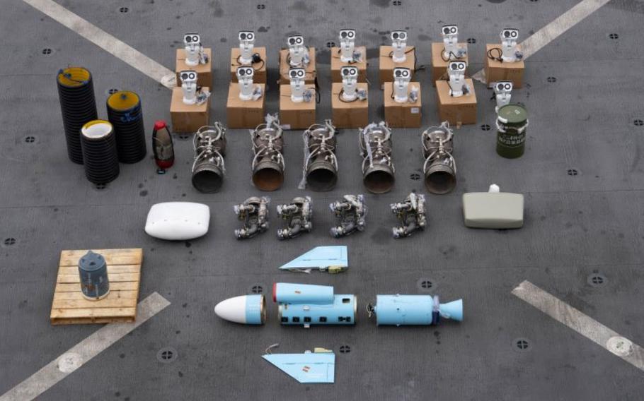Weapons components lie on a gray surface.
