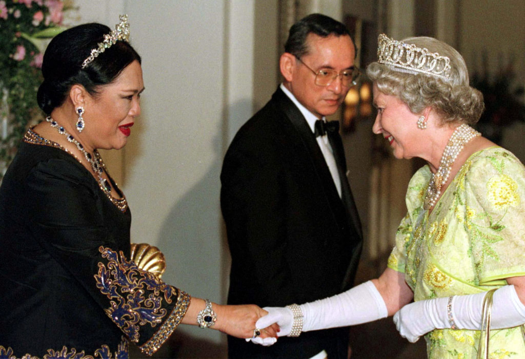 FILE PHOTO: Britain's Queen Elizabeth II smiles as she greets Thailand's Queen Sirikit as the King Bhumibol Adulyadej look...