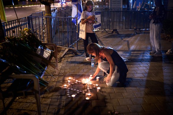 People light candles outside Abu Kabir, the forensic institute where the identification process is being carried out on the bodies of returned hostages.