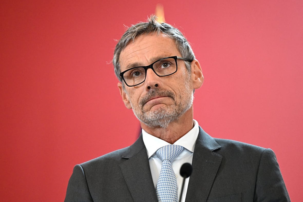 A man stands in front of a microphone