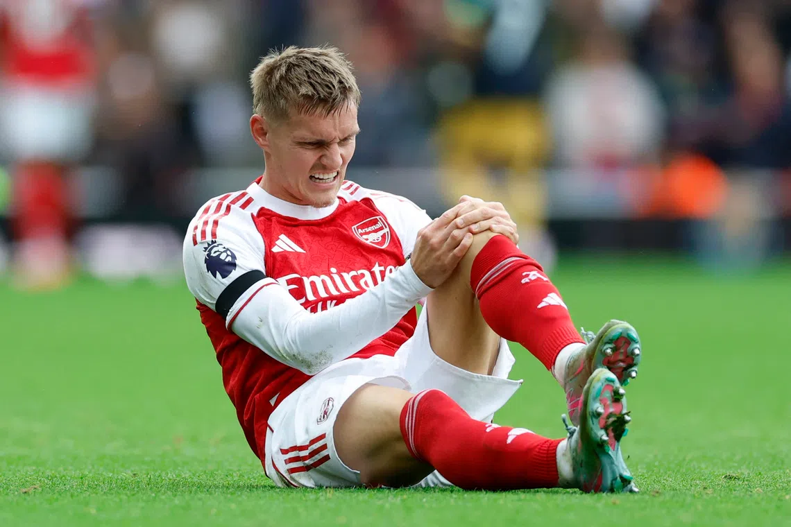 Soccer Football - Premier League - Arsenal v West Ham United - Emirates Stadium, London, Britain - October 4, 2025 Arsenal's Martin Odegaard reacts after sustaining an injury Action Images via Reuters/Peter Cziborra