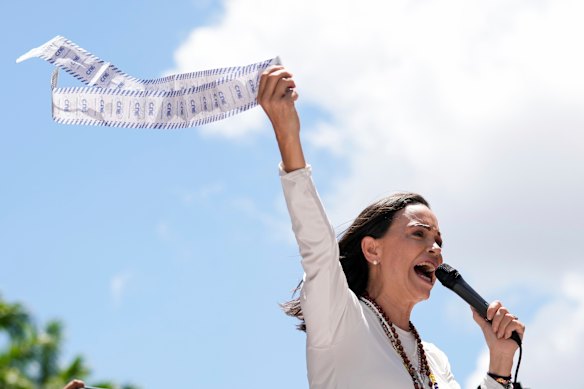 Maria Corina Machado holds up tally sheets during a protest against the re-election of President Nicolás Maduro.