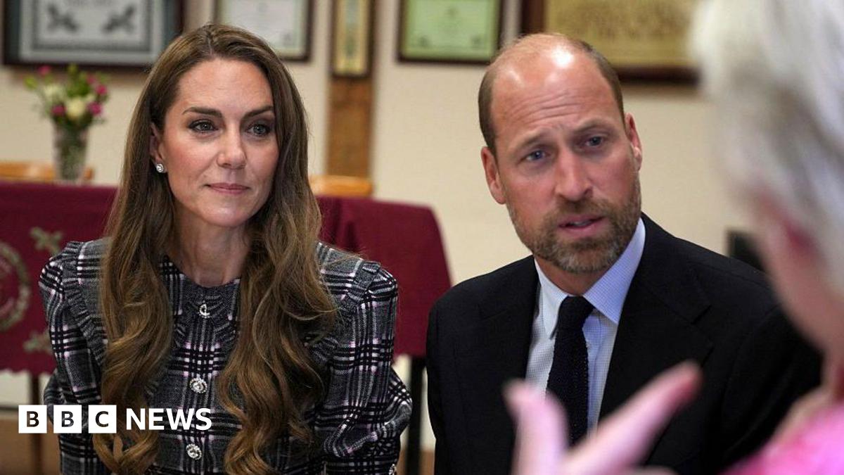 William and Kate sat down facing an elderly woman who is talking to them.