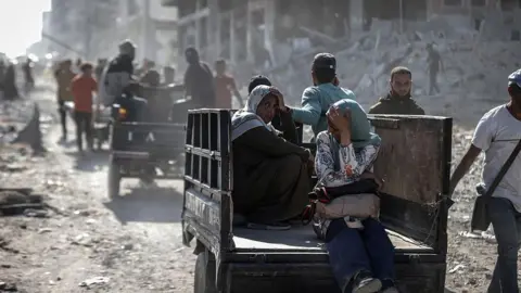 Getty Images A woman on a cart in dusty landscape. 