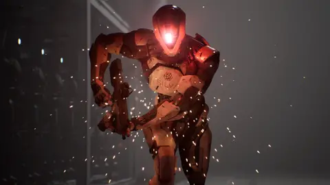 Build a Rocket Boy A humanoid robot holds an assault rifle as it runs towards the viewer. A large red light in the centre of its head glows red as sparks shower down around it.