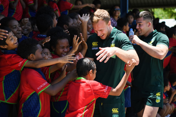 NRL players are mobbed during a trip to PNG for a PM’s XIII match a few years ago.