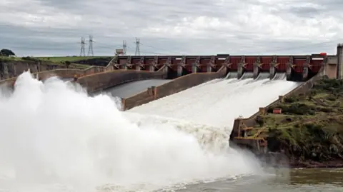 AFP via Getty Images Water gushing out of the giant Itaipu Dam on the Paraná River between Paraguay and Brazil