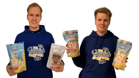 Swedish Candy Land Daniel and Tobias Johansson are co-founders of Swedish Candy Land. They are wearing purple hoodies with the name of their company and holding bags of Swedish candy