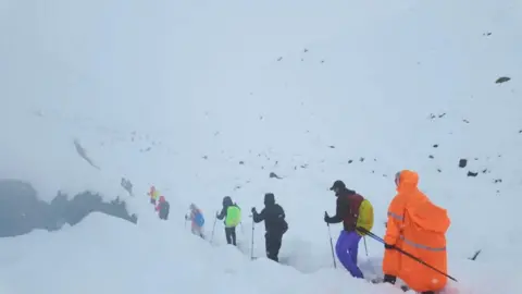 Reuters A line of trekkers descends a path covered by snow