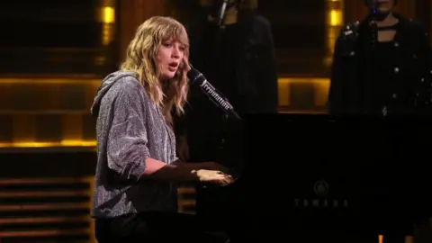 Getty Images Taylor Swift singing at a piano
