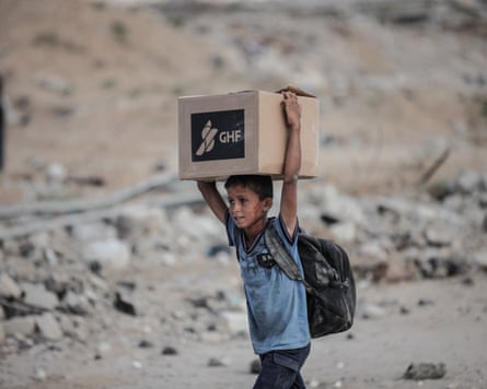 A child carrying a box of aid supplies