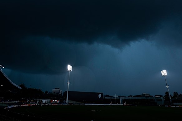 Rain falls at Ikon Park in Carlton on Sunday after lightning strikes forced an AFLW game to be suspended for 40 minutes.