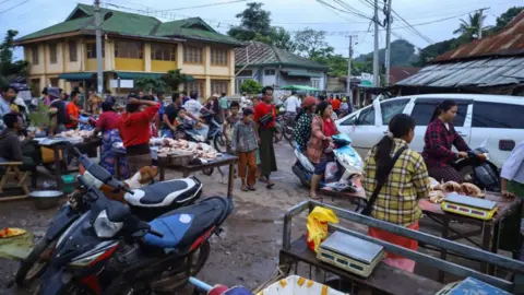 Getty Images This photo taken on July 3, 2024 shows people buying food in a street market in Kyaukme in Myanmar's northern Shan State.