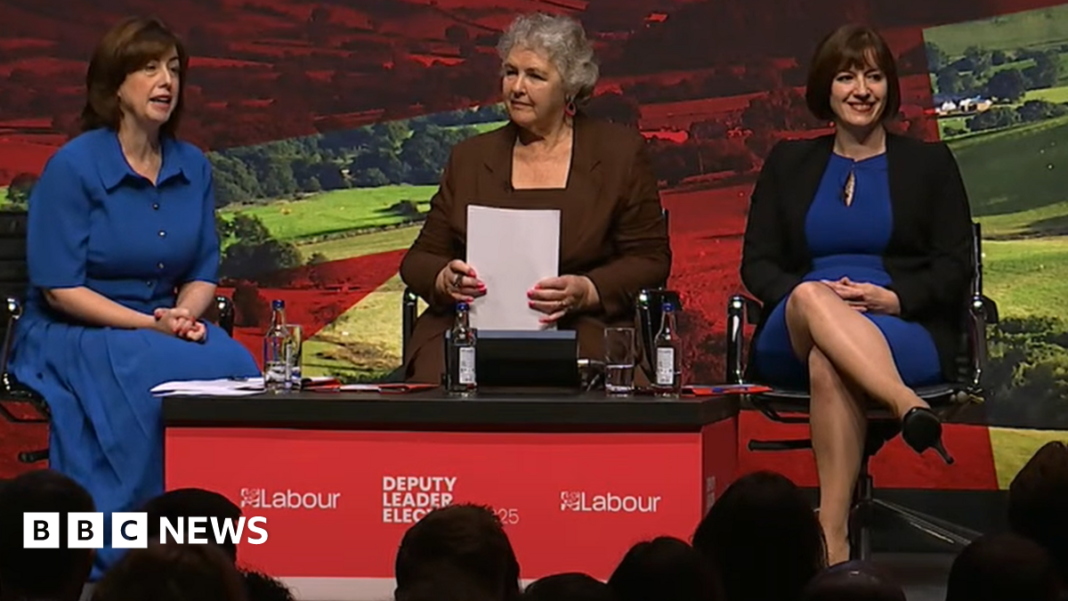 Lucy Powell and Bridget Phillipson, both wearing blue dresses, sit either side of a woman moderator on the main stage at the Labour Party conference in Liverpool