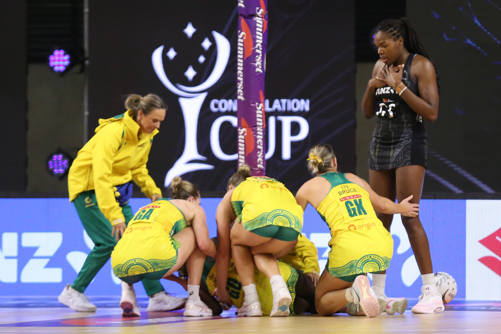 Australian teammate gather around an injured Sunday Aryang. Image: Graeme Laughton-Mutu
