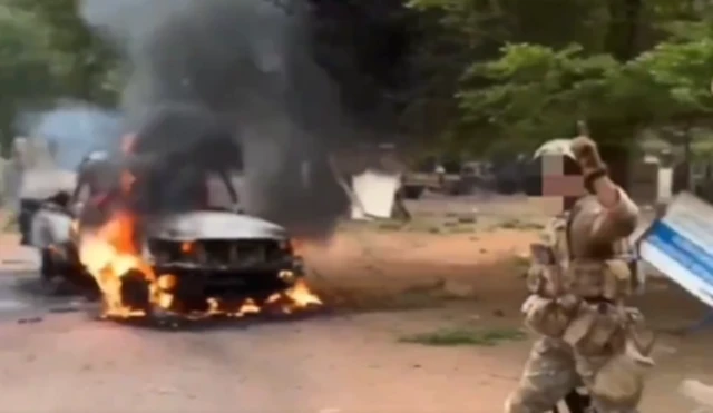 A screengrab from a verified video showing a heavily armed paramilitary soldier near a burning pick-up truck in rural Mali