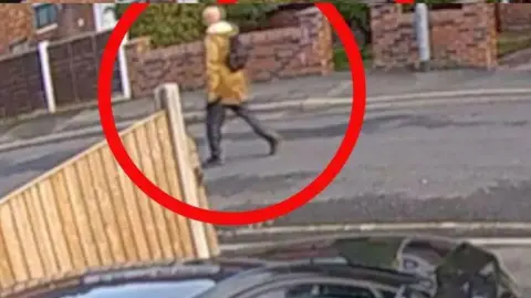 Next doorbell footage which shows a man wearing a mustard jacket on foot walking past houses
